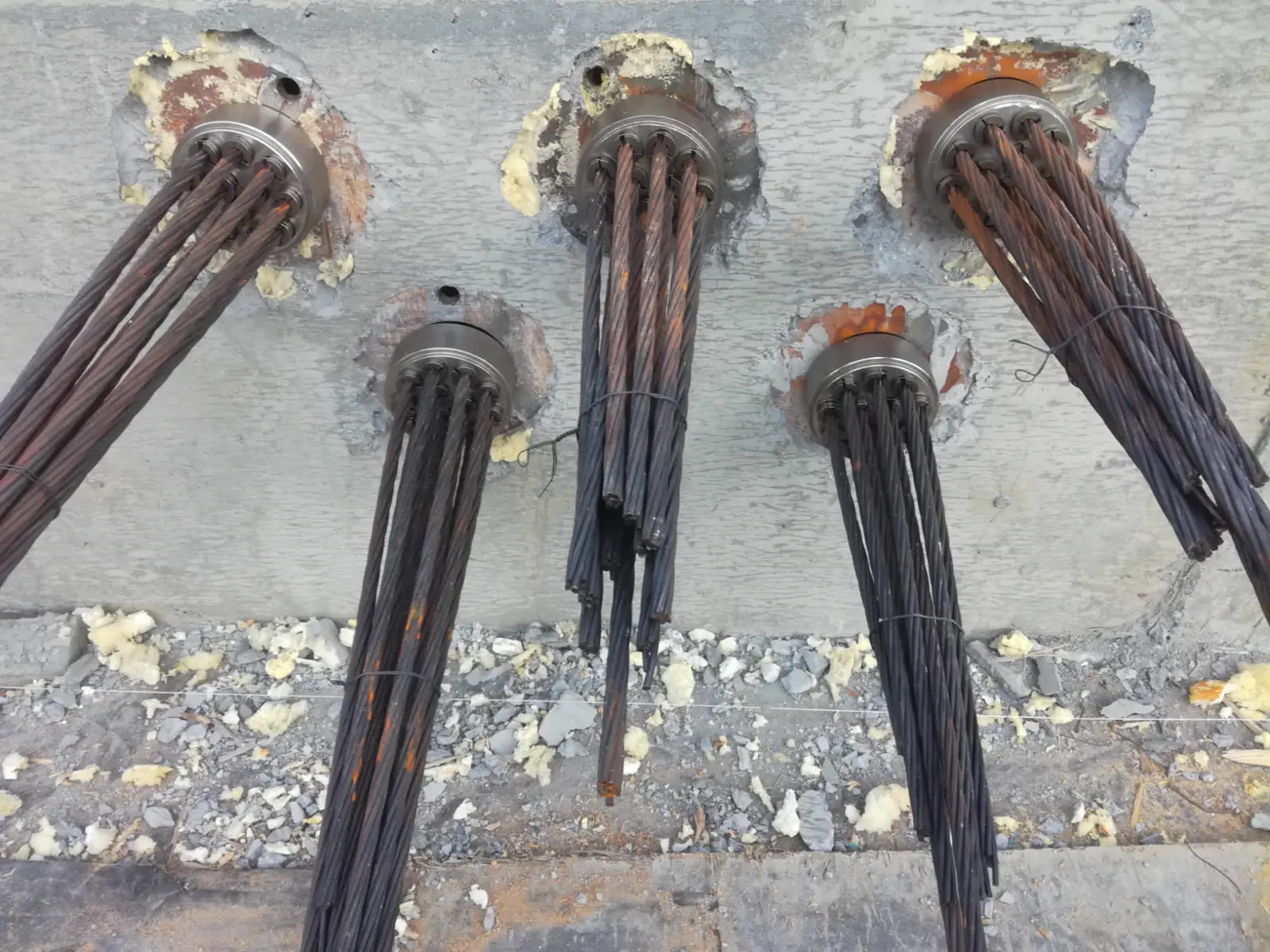 Cordones de tendones que sobresalen de los anclajes en un paramento de hormigón
