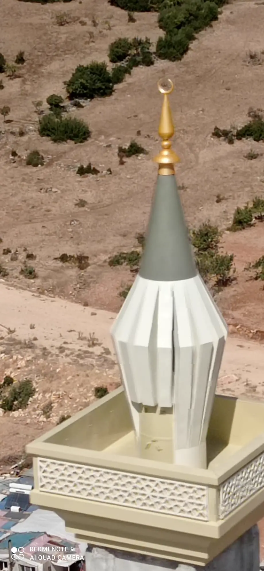Remate de un minarete de acero con media luna sobre el balcón
