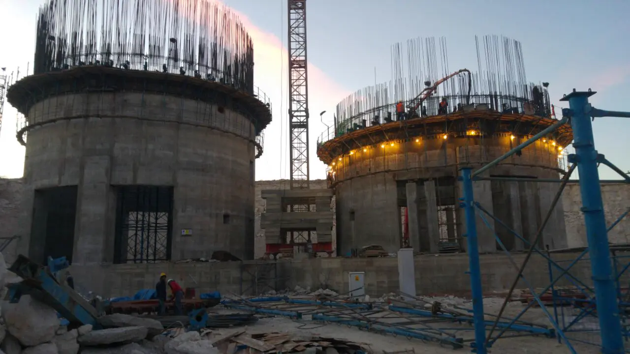 Plataformas del encofrado deslizante iluminadas en los silos gemelos de Ilgın al anochecer