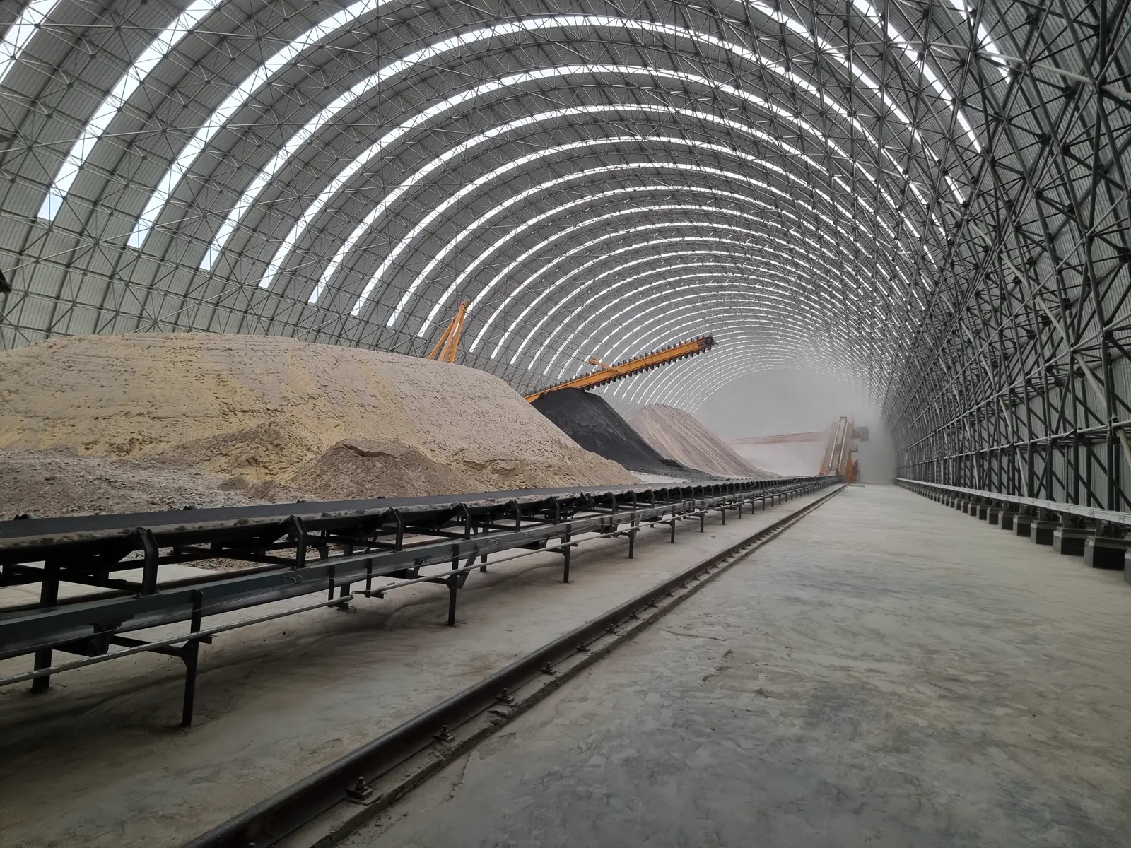 Acopio de material y cinta transportadora en el interior de la nave de almacenamiento de Yizaj