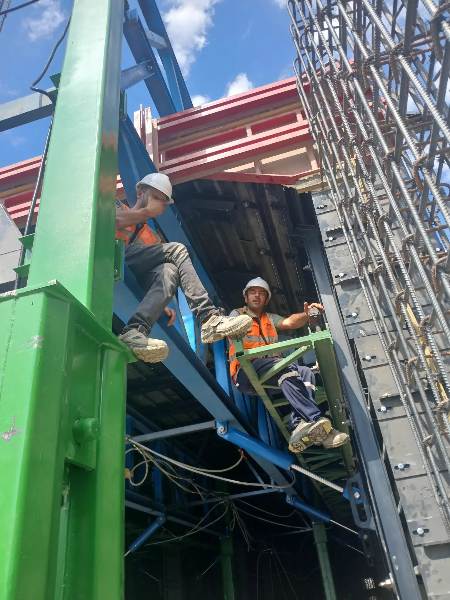 Équipe au travail sur l’ossature du coffrage hydraulique, parmi le ferraillage des parois